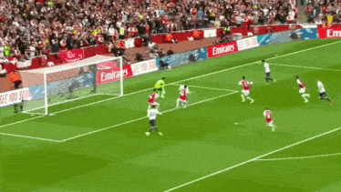 a soccer game is being played in front of a emirates advertisement