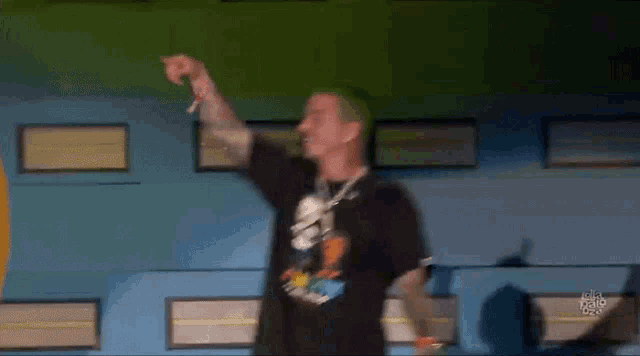 a man with green hair is singing into a microphone on stage