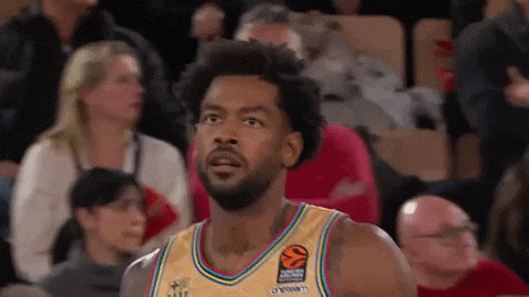 a basketball player wearing a colorful jersey is looking at the camera .