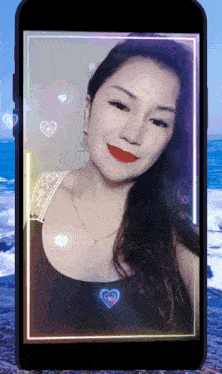 a woman 's face is displayed on a cellphone screen