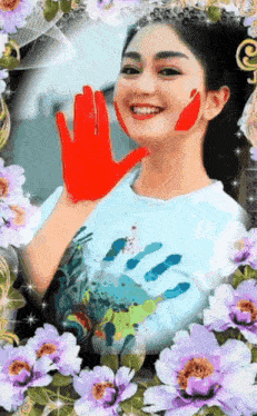 a woman with a red hand painted on her face surrounded by purple flowers