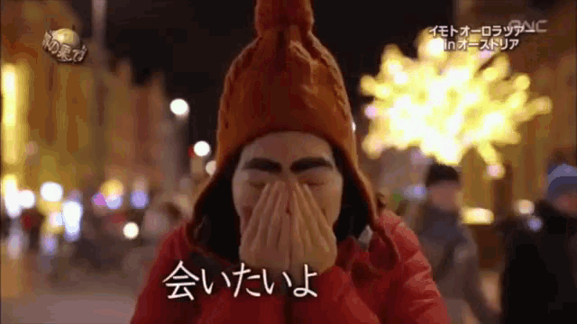 a person wearing a red jacket and a chicken hat covering their face
