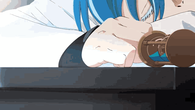 a person with blue hair laying on a table with a hourglass in front of them