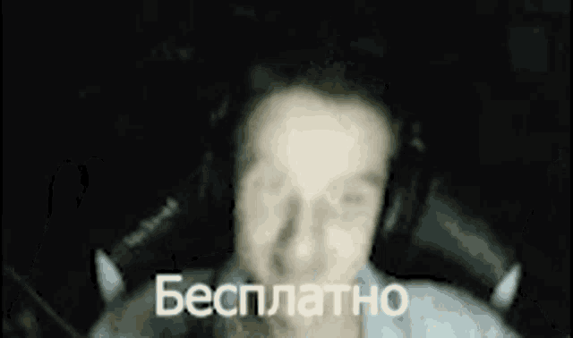 a blurry picture of a man wearing headphones and a sign that says бесплатно
