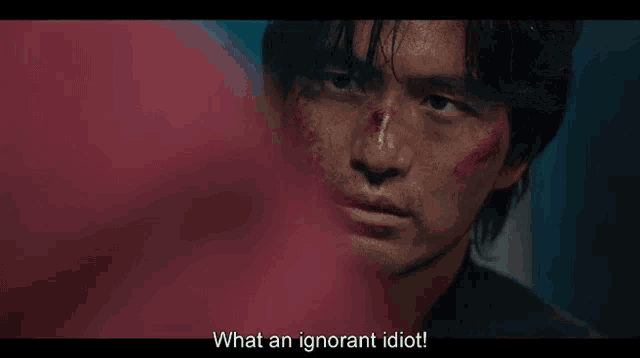 a man with blood on his face is standing in a room with a water cooler