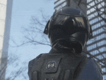 a person wearing a helmet and a backpack with the letter r on the back
