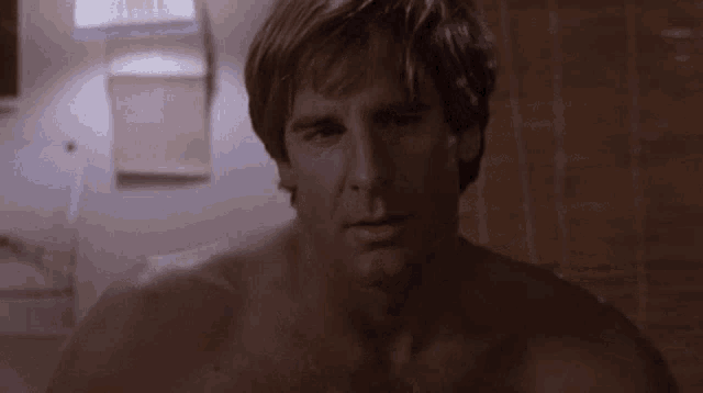 a man without a shirt is looking to the side