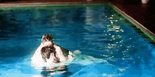 a man and woman are swimming in a swimming pool .