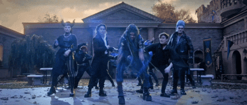 a group of people are dancing in front of a building that says ' a ' on it