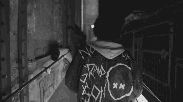 a black and white photo of a person wearing a jacket that says son on the back