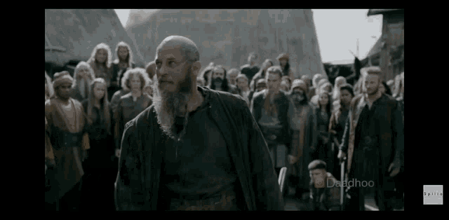 a man with a beard is standing in front of a group of people .