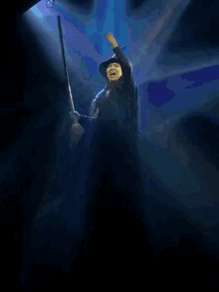 a man in a wizard hat is standing in the dark