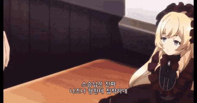 a girl in a red dress is sitting at a table with korean writing