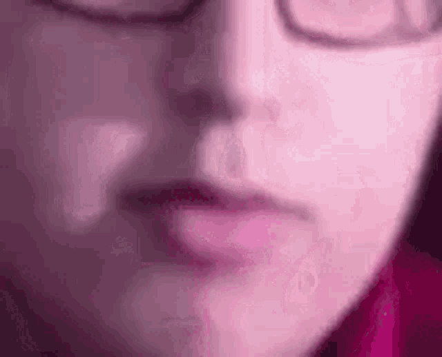 a close up of a person 's face wearing glasses .