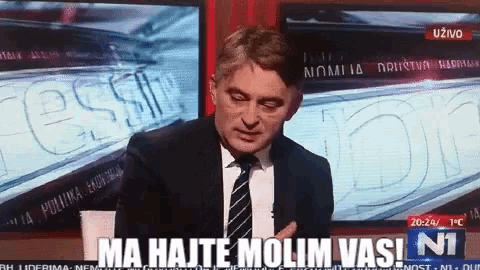 a man in a suit and tie says ma hajte molim vasi n1 on a tv screen