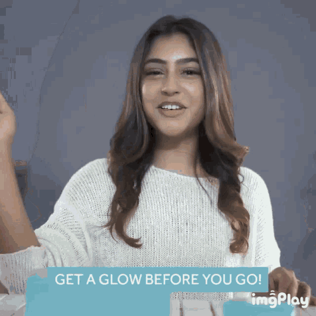 a woman in a white sweater with the words get a glow before you go behind her