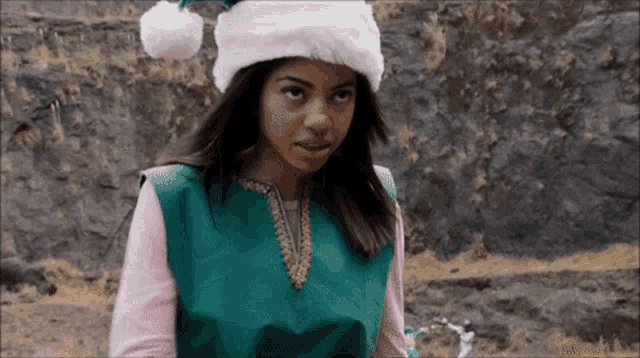 a woman wearing a santa hat and a green top