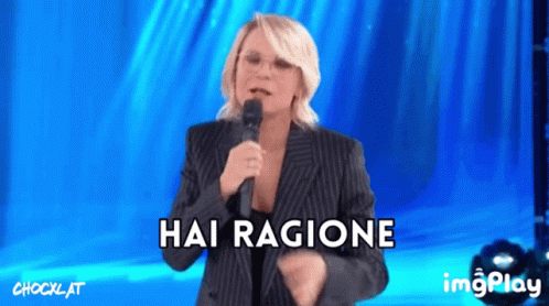 a woman singing into a microphone with the words hai ragione written below her