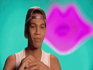a man wearing a baseball cap stands in front of a pink lips