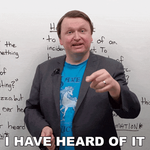 a man wearing a blue shirt with a unicorn on it points at something and says i have heard of it