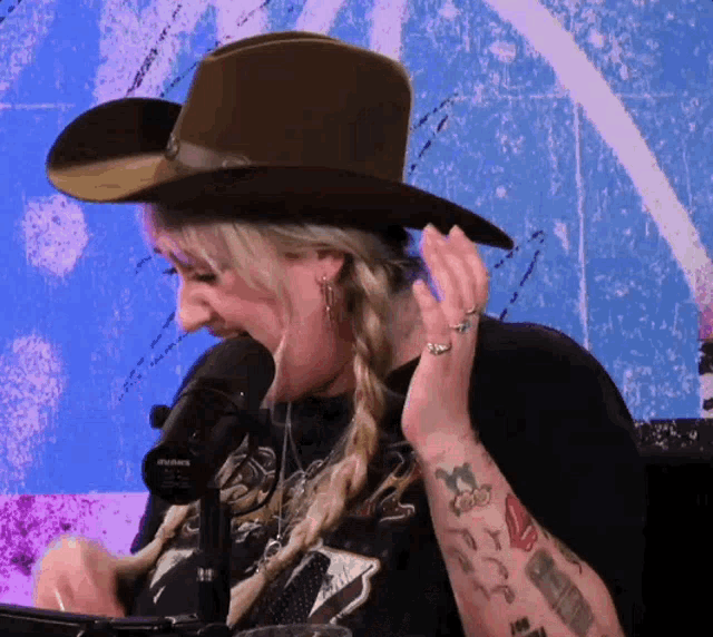 a woman wearing a brown cowboy hat and a black shirt