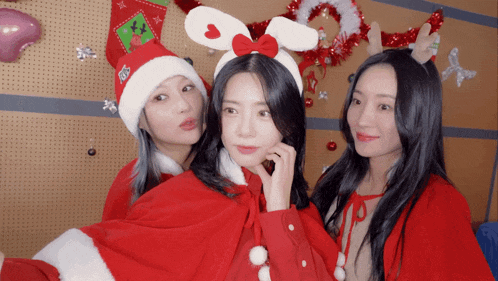 three women are posing for a picture in christmas costumes