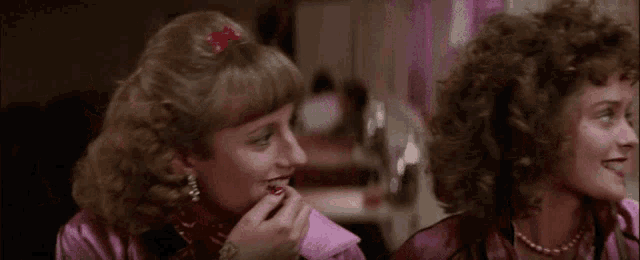 two women are standing next to each other in a room .