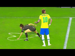 a soccer player and a referee are standing on a field .