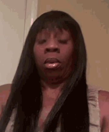 a woman with long black hair is making a funny face