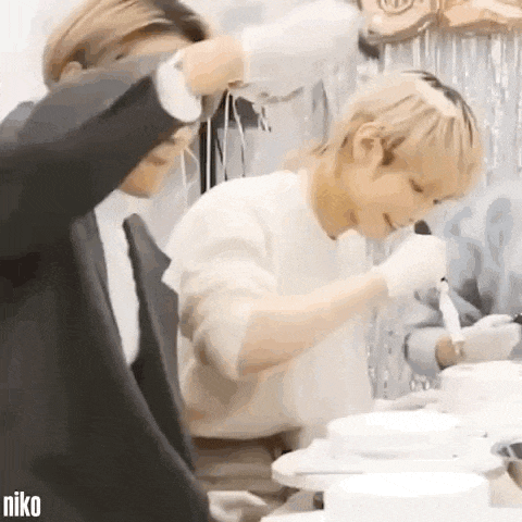 two men are standing next to each other in a kitchen .