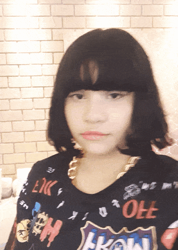 a girl wearing a shirt that says " oh " looks at the camera