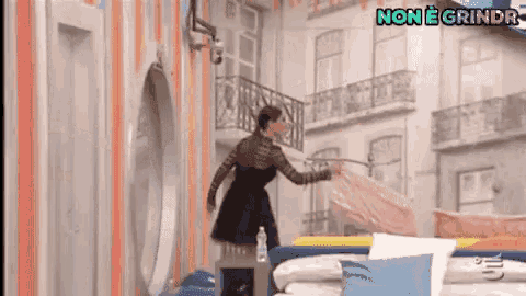 a woman is making a bed in a room with the words non e grindr on the bottom right