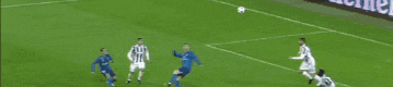 a soccer player is kicking a soccer ball on a field while another player watches .