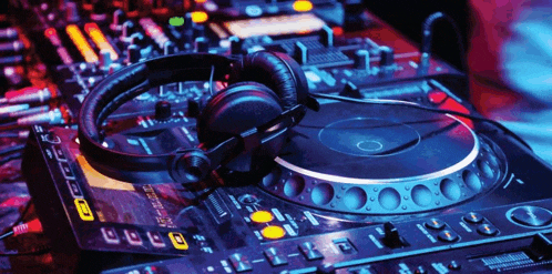 a pair of headphones are sitting on top of a dj mixer