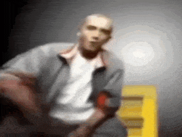 a blurry picture of a man standing in front of a yellow ladder .