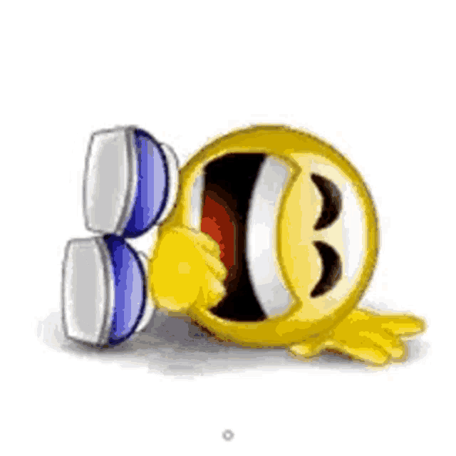 a smiley face with a fist in its mouth is sitting next to a computer monitor .