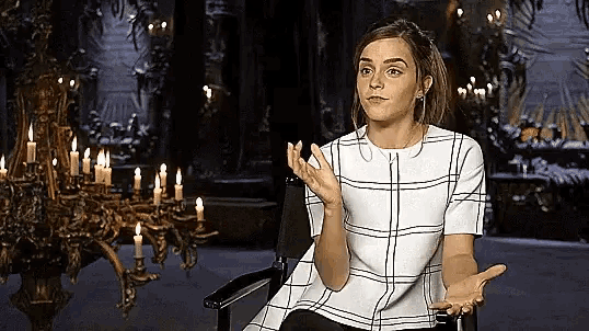 a woman in a plaid shirt is sitting in a chair in front of candles .
