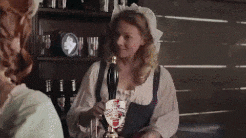 a woman is pouring beer from a tap that has a shield on it that says ' scotch porter '