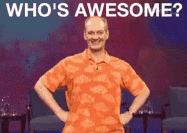 a man in an orange shirt is standing with his hands on his hips and the words " who 's awesome " above him