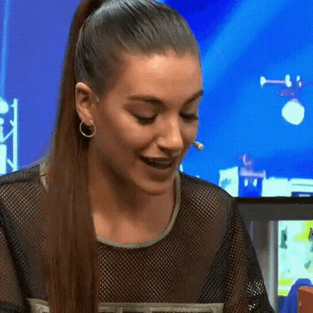 a woman with a ponytail and earrings is smiling