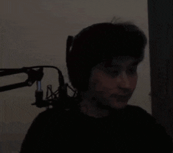 a woman is sitting in front of a microphone in a dark room .
