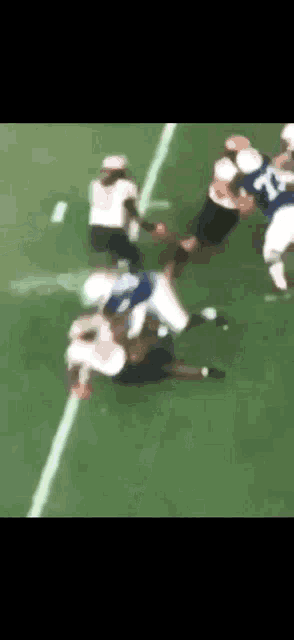 a group of football players are playing a game of football .