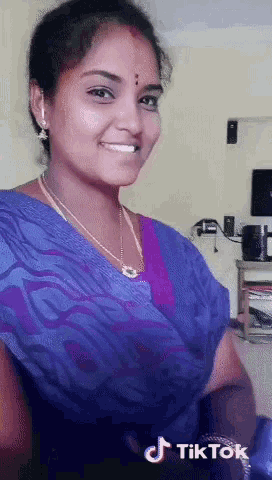 a woman in a purple top is smiling and a tiktok logo is visible