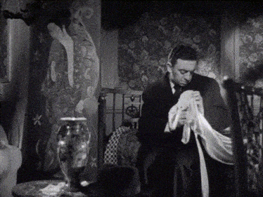a man sits in a chair holding a piece of cloth