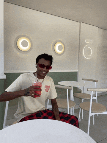 a man sitting at a table with a drink in his hand