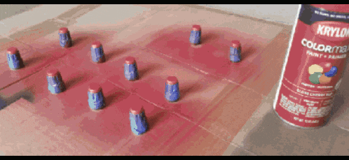 a bottle of krylon color max paint sits on a table next to a bunch of paint caps