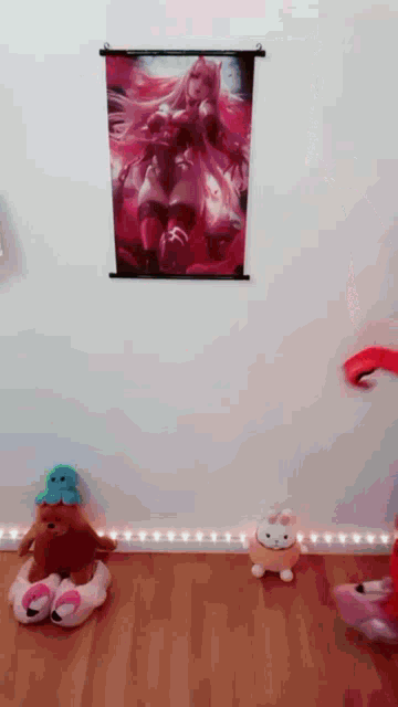 a poster of a girl with long hair hangs on a wall next to stuffed animals
