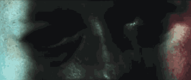 a close up of a person 's face in a dark room with a blurred background .