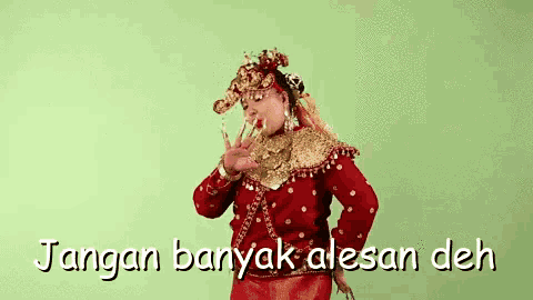 a woman in a red dress and gold jewelry is dancing .