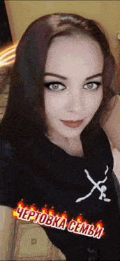 a woman is wearing a black shirt that says ' чертовка семьи ' on it